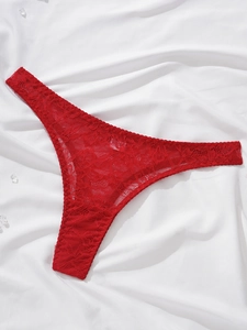 Detail of red floral lace thong on silk background with crystal beads decoration