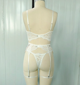 Detail view of white lace lingerie set featuring elegant pearl chains and metal adjusters