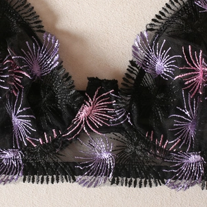 Close-up of black lace bra with pink and purple floral fireworks embroidery details