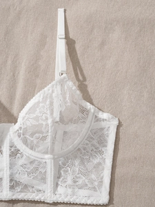 Close-up of white floral lace lingerie set showing boning and intricate mesh texture