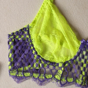 Detailed close-up of neon yellow lace cup and purple crochet trim with silk bow detail