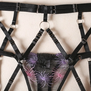 Close-up of black mesh garter with purple firework embroidery and metal O-ring details