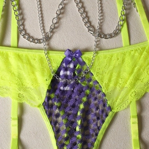 Detailed lace texture with purple mesh and decorative silver metal chain on lingerie