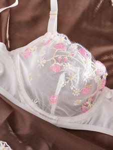 Détails de broderie florale sur soutien-gorge en maille blanche avec finitions en satin
