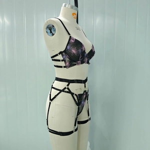 Detail of fireworks embroidery on black mesh lingerie set with garter straps