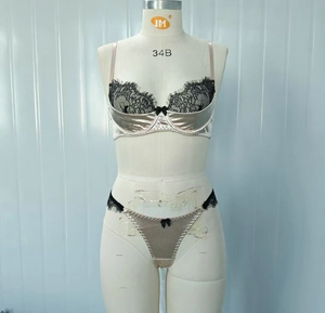 Detail von Champagner-Satin-BH mit schwarzer Wimpernspitze und Schleife auf Mannequin