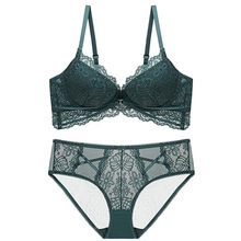 Flat lay of deep green floral lace lingerie set with push-up bra and sheer lace panties