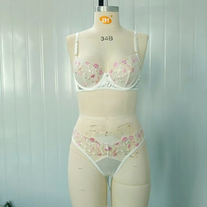 Détail de l'ensemble lingerie en résille blanche avec broderie fleurie et armatures
