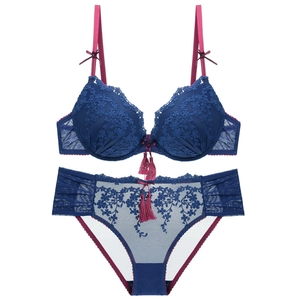 Elegant dark blue lace bra set with floral embroidery and decorative red tassels
