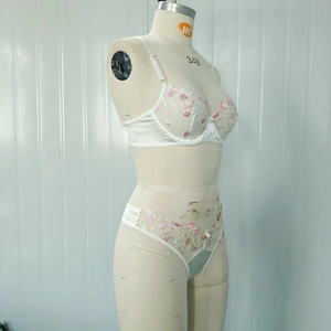 Détail du soutien-gorge en dentelle blanche avec broderie florale et armatures