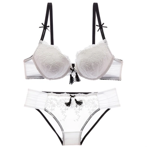 Elegant white lace lingerie set with black bow accents and tassels on a clean white background