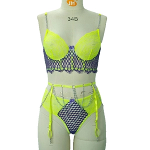 Fluorescent yellow lace lingerie set with metal chains and purple trim on mannequin