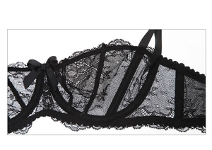 Detail of sheer black lace bra featuring intricate floral embroidery and silk bow accent