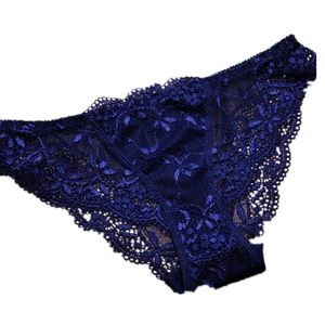 Detail of luxury royal blue lace panties featuring floral embroidery and scalloped edges