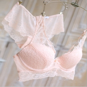 Detailed view of a light pink floral lace lingerie set with a bow and adjustable straps