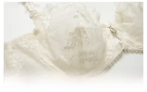 Détail du soutien-gorge en dentelle florale blanche avec nœud et pendentif argenté