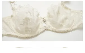 Détail de broderie en dentelle florale avec nœud en ruban et pendentif en strass