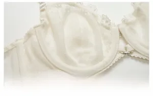 Détail d'un soutien-gorge en dentelle beige montrant la maille fine et la couture invisible