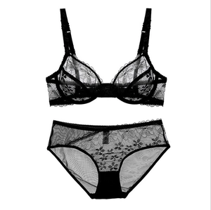 Detailed close-up of black sheer lace lingerie set with floral embroidery on white background