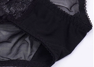 Detailed close-up of delicate black lace embroidery and breathable mesh fabric on bra