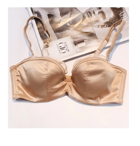 Détail d'un soutien-gorge en satin champagne avec bordure en dentelle blanche et fines bretelles