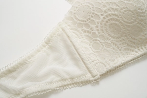 Gros plan sur la dentelle florale blanche avec doublure en mesh et bords festonnés