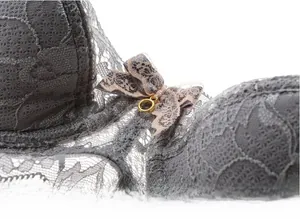 Detail of grey lace bra featuring a delicate bow and gold ring pendant ornament