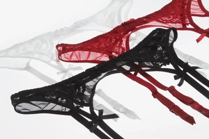 Détail de porte-jarretelles en dentelle réglables en noir, rouge et blanc avec nœuds