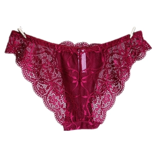 Close-up of wine red lace panties with floral patterns and scalloped edges on white background