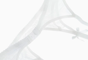 Détail de lingerie en dentelle blanche avec nœud décoratif et bretelles réglables
