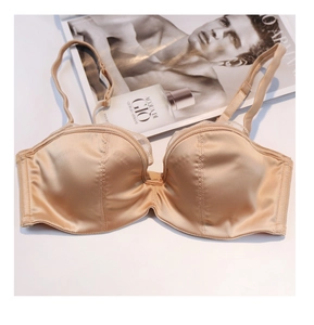 Soutien-gorge élégant en satin champagne avec dentelle à côté de magazine de luxe