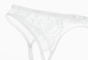 Gros plan détaillé sur un string en dentelle blanche avec mesh fin et petit nœud déco