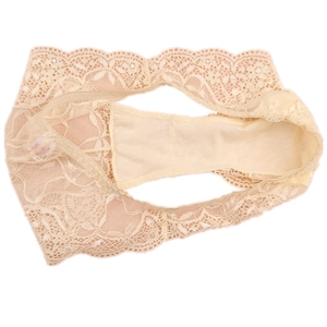 Macro detail of luxury floral lace pattern and wavy edges on beige low-waist panties