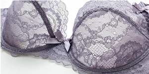 Dettaglio del reggiseno in pizzo lavanda con fiocco di raso e motivi floreali ricamati