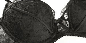 Détail d'un soutien-gorge en dentelle noire avec baleines de maintien et petit nœud