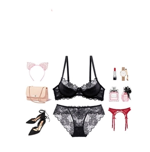 Flat lay of black floral lace bra set with elegant mesh detailing and lingerie accessories