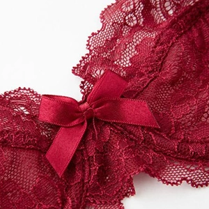 Set lingerie in pizzo rosso con ricamo floreale e dettaglio di un fiocco in raso