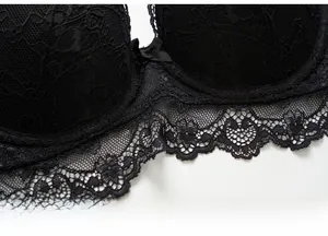 Detailed macro shot of fine black floral lace and a central bow on a French bra