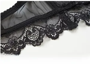 Macro detail of intricate black floral lace and scalloped edges on the bra cup fabric