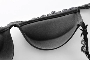 Macro detail of black lace trim and thick padded inner lining for push-up bra comfort