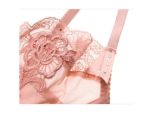 Détail de broderie en dentelle rose avec boucles métalliques réglables sur les bretelles
