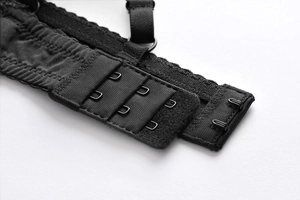 Detail of black lingerie bra back closure featuring three-row two-hook metal fasteners