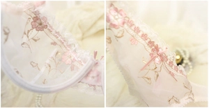 Dettaglio macro di pizzo francese e fiocco di raso rosa su una spallina di reggiseno