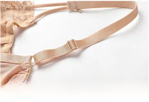 Close-up of adjustable lace straps and delicate floral mesh texture on beige bra set