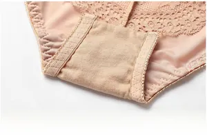 Detail view of cotton crotch lining and lace trim on skin-tone mesh panties