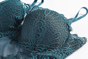 Close-up of deep green eyelash lace and mesh fabric detailing on the bodysuit