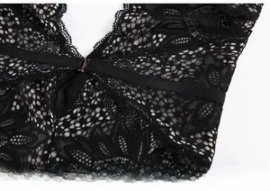 Dettaglio di body in pizzo nero con fibbia in metallo oro rosa e cinturino in vita