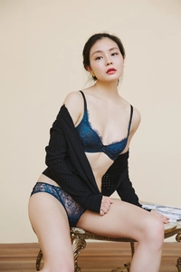 Detailed view of dark blue eyelash lace lingerie set worn by a model in a cozy setting