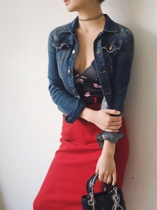 Detail of a black floral tube top paired with a red high-waist skirt and denim jacket
