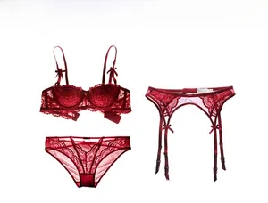 Dettaglio di un set reggiseno in pizzo rosso con fiocco e reggicalze coordinato